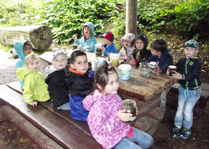 Die Kinder im Wald um einen Tisch versammelt