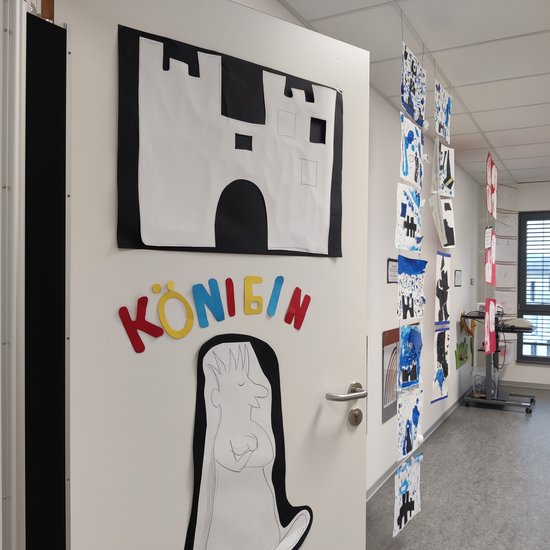 An einer Tür hängen 2 Bilder