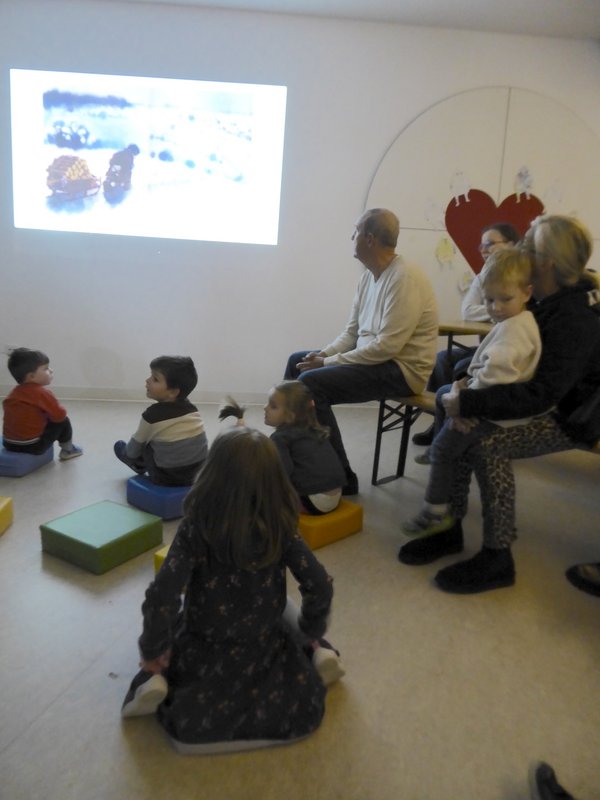 Kinder und Erwachsene schauen Bilderbuchkino