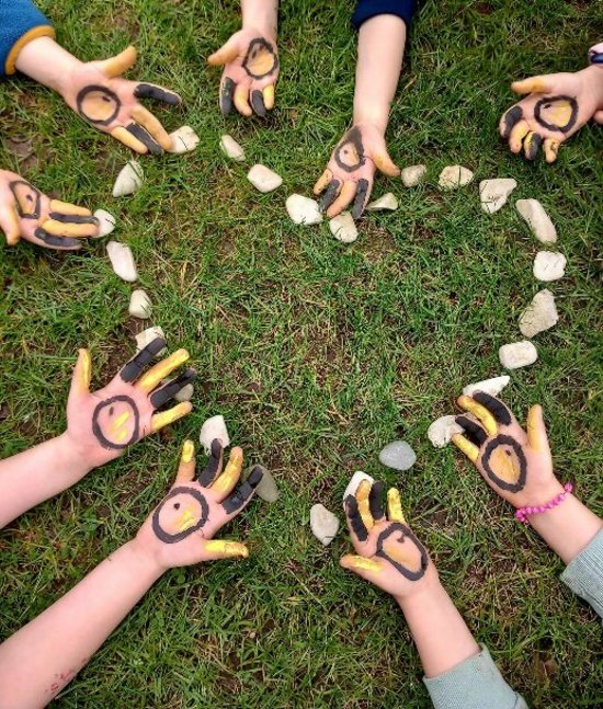 Mit Steinen gelegtes Herz und Hände