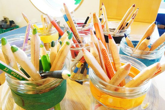 Viele Buntstifte in Gläsern auf einem Tisch in der Kita Bunte Welt
