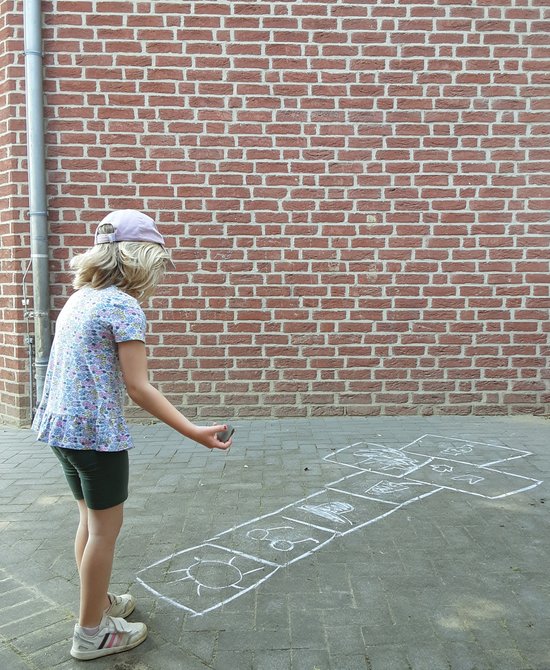 Kind draußen bei einem Hüpfspiel