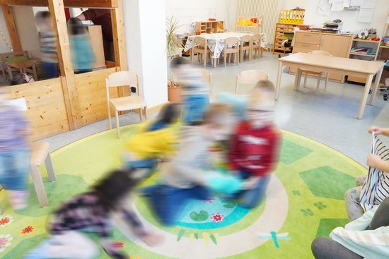 Spielende Kinder auf einem Spielteppich in der Kita Bunte Welt