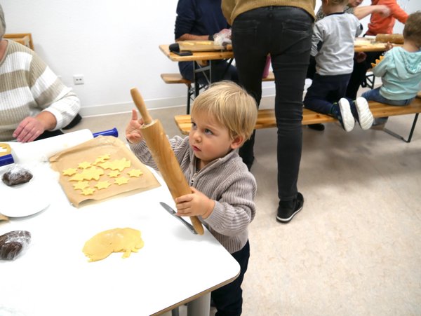 Kind mit Nudelholz hilft Plätzchen zu backen
