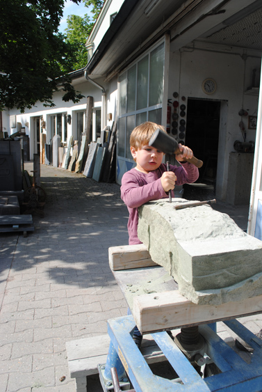 Ein Kind bearbeitet einen großen Stein