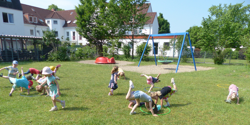Kinder turnen auf einer Rasenfläche