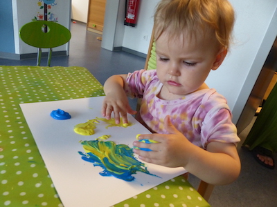 Ein Kind malt mit Fingerfarbe