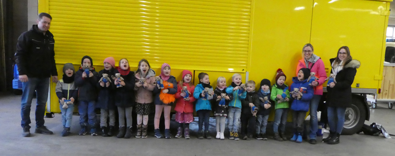 Gruppenfoto vor gelben Fahrzeug