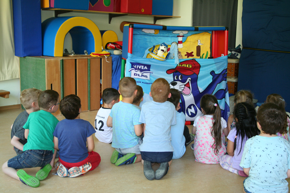 Mehrere Kinder schauen ein Puppenspiel