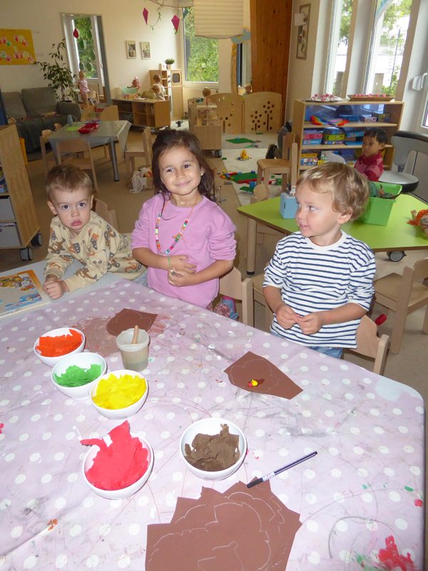 Kinder sitzen am Tisch und basteln