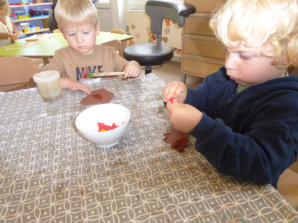 Kinder sitzen am Tisch und basteln