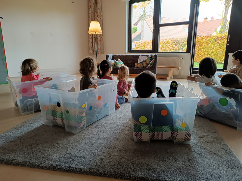 Kinder sitzen in Kunststoffboxen