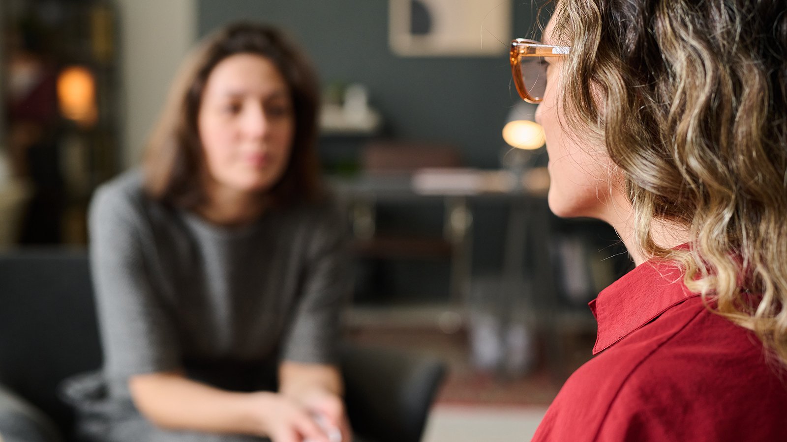 AWO Schwangerschafts_Familienberatung Zwei Frauen sitzen sich gegenüber, schauen ernst, sind im Gespräch